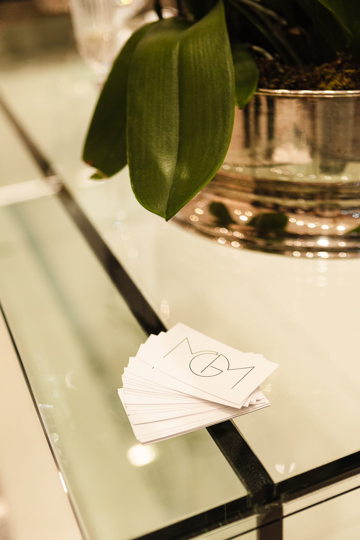 Cartões MGM Haute Beauté sobre mesa de vidro — identidade e sofisticação