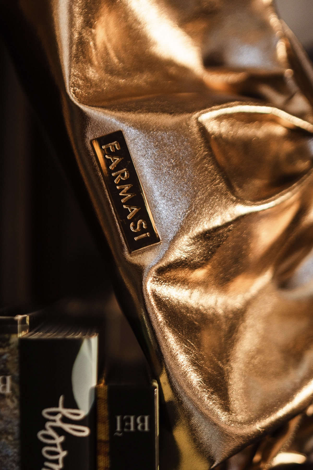Bolsa dourada com produtos Farmasi em composição editorial